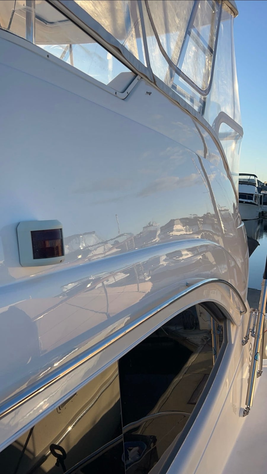 Flybridge cruiser topsides gleaming at a marina berth